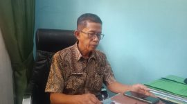 DISPLIN: Plt Kepala Dinas Ketahanan Pangan dan Pertanian (DKPP) Pamekasan, Nolo Garjito saat merapikan berkas di kantor kerjanya. Jum'at (13/09). (ROZIEN ABQORY/TELITI) 